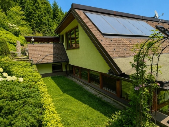 Hausansicht in grüner Gartenlandschaft