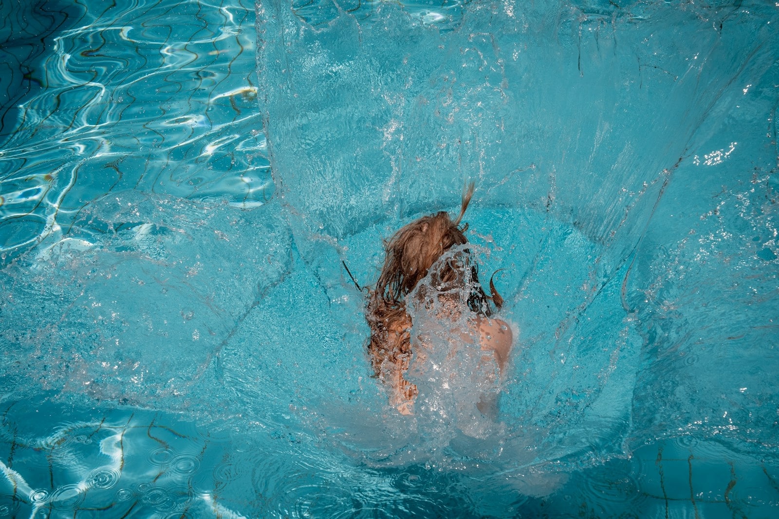 Pool A person is diving into a swimming pool.